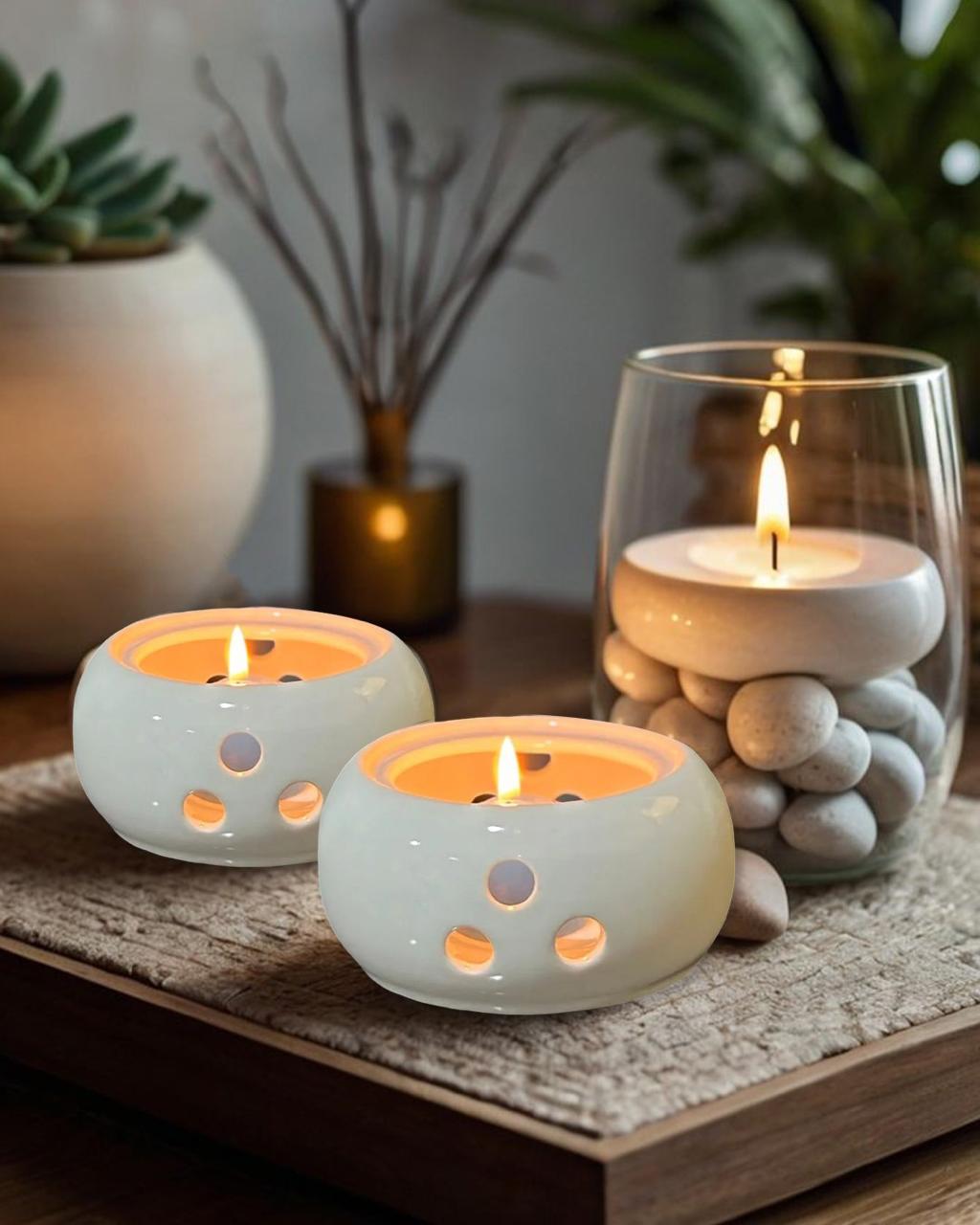 Two lit candles in ceramic holders on a wooden surface with decorative elements.